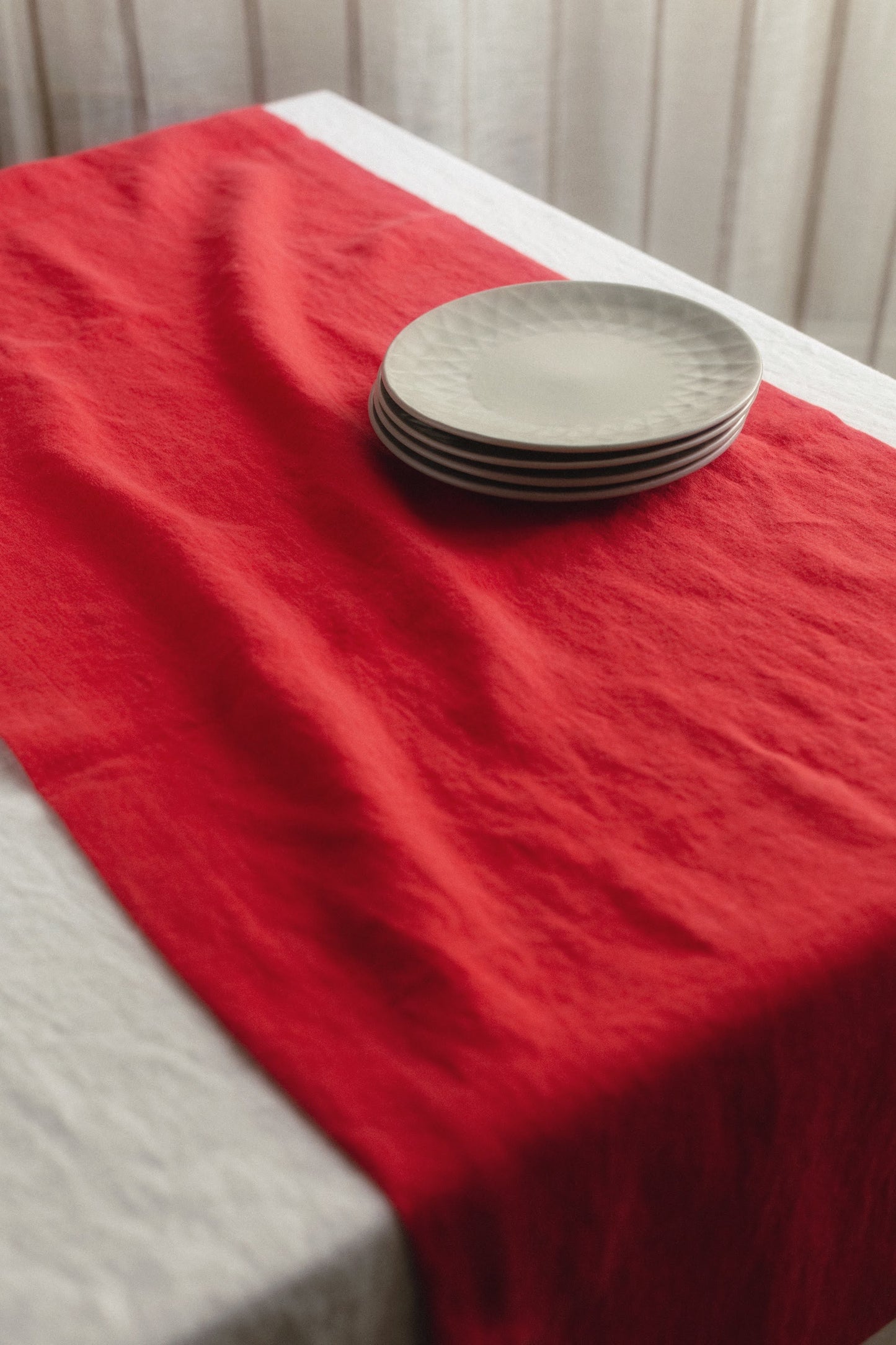 Stack of plates on a red table runner with a neutral background