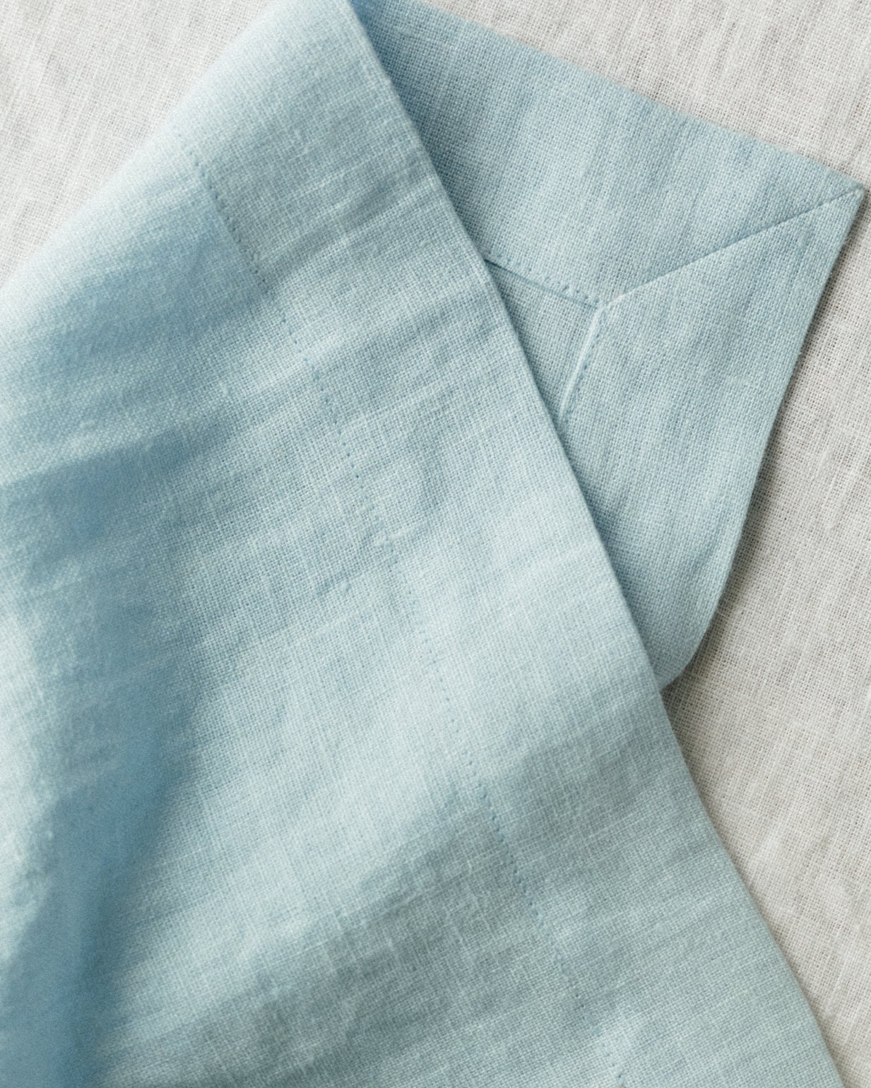 Light blue linen napkinon a light table runner