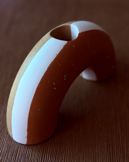 Arch candle holder with white stripe on a wooden surface