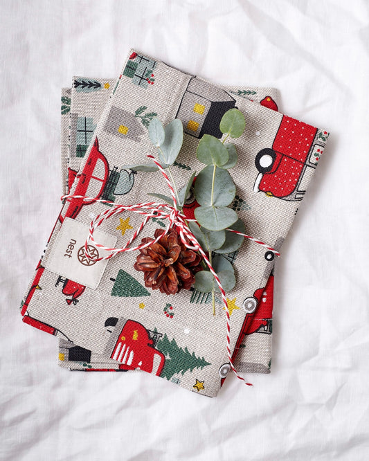 Set of linen placemats with Christmas designs on a white surface