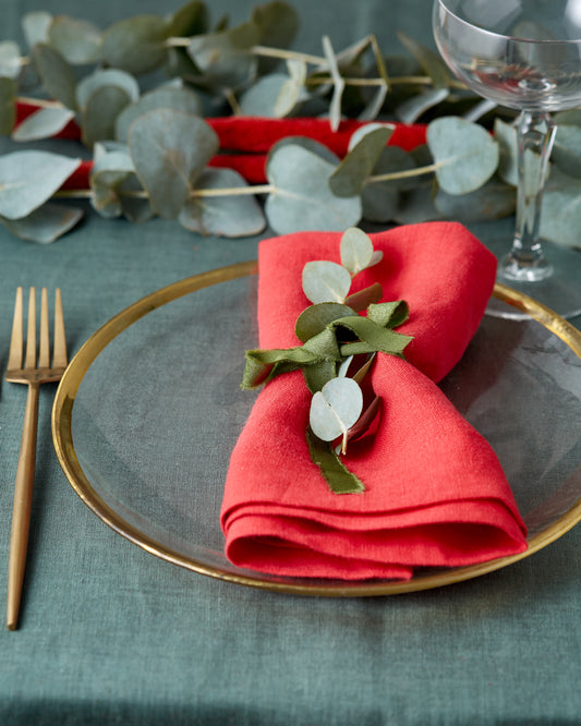 Elegant summer table setting with inen runner and napkins, styled with eucalyptus and golden flatware by Fine Dining 4 Home
