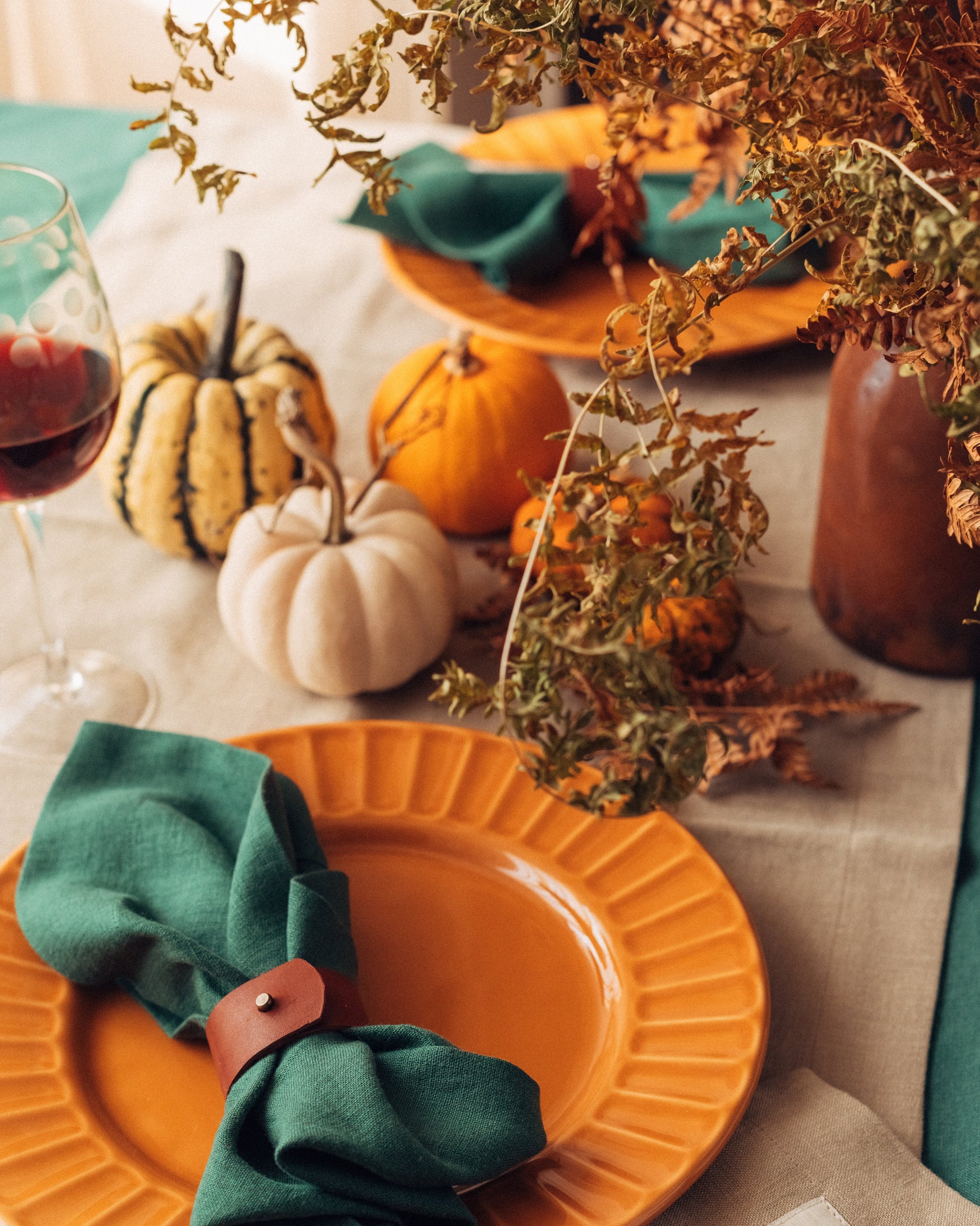 Autumnal table setting with orange plates, green napkins, and pumpkins. Fine Dining 4 Home